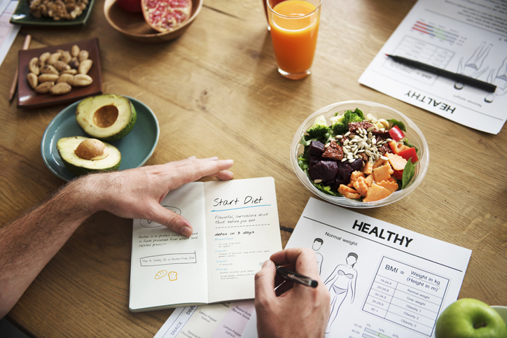 Writing a diet plan with healthy food on the table